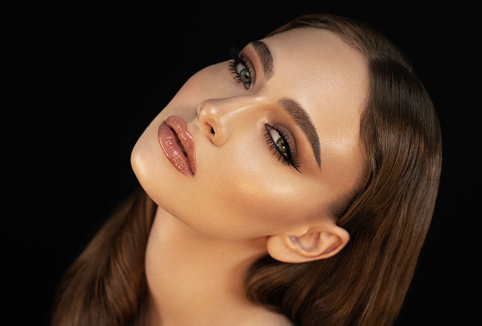 Woman natural face makeup posing with head tilted back and mouth slightly parted, staring at camera 